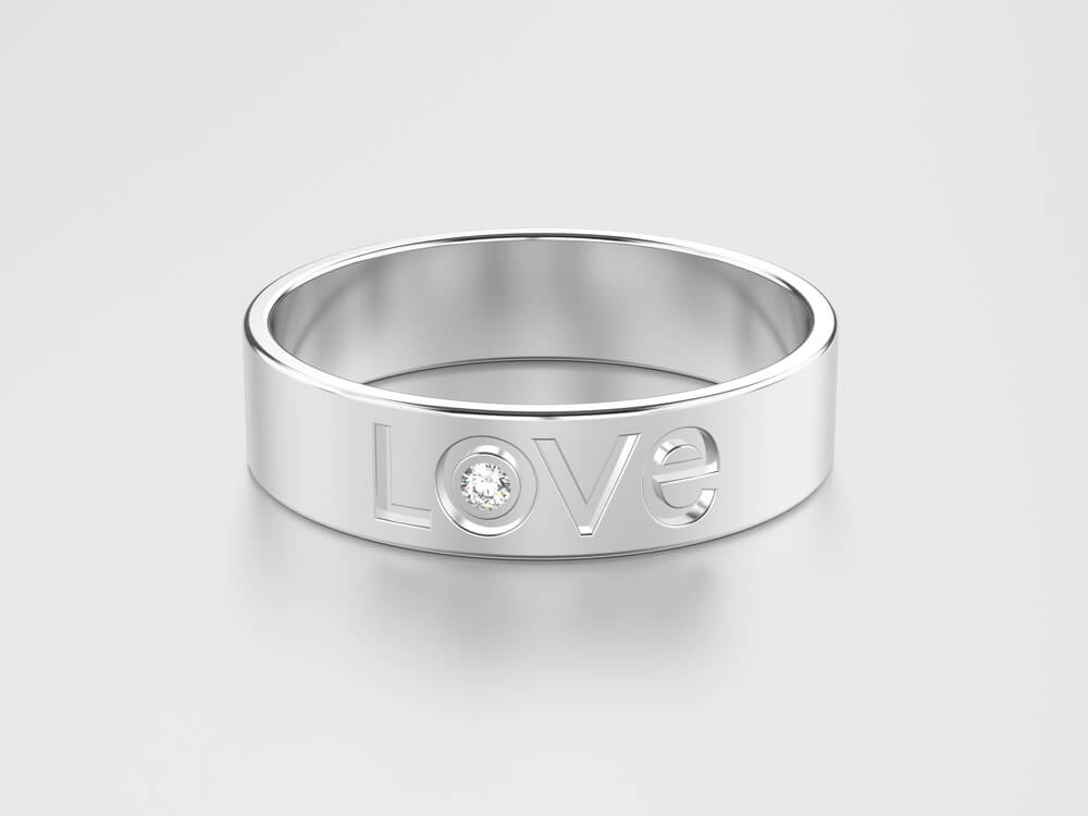 Trauring-Aussengravur "LOVE" mit Steinbesatz auf silbernen Ring